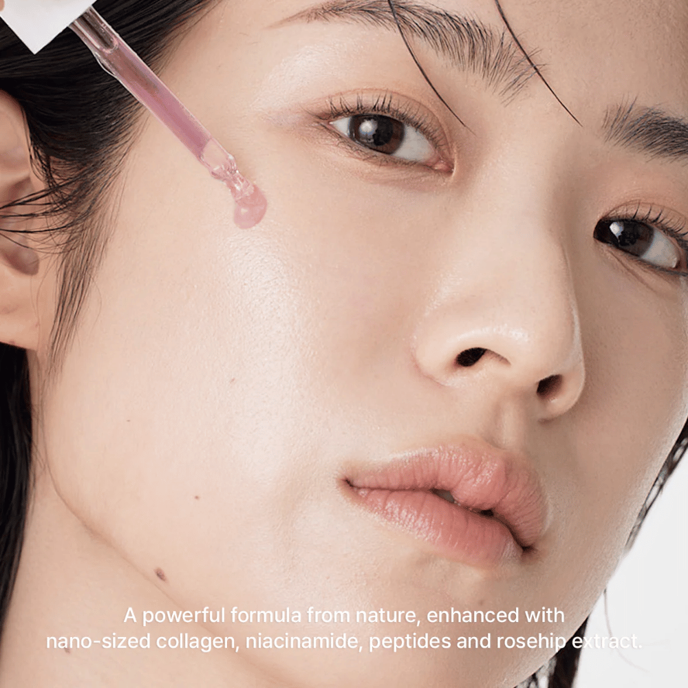 Gros plan sur un visage où Arencia Red Smoothie Serum 8 est appliqué avec une pipette. Le sérum a une teinte rose clair et contient du nano-collagène, de la niacinamide, des peptides et de l'extrait d'églantier.