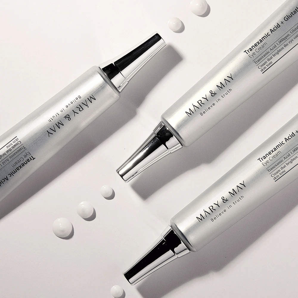 Image de produit stylisée de Mary&May Tranexamic Acid + Glutathione Eye Cream montrant la consistance de la crème et l'accent sur le soin éclaircissant des yeux.