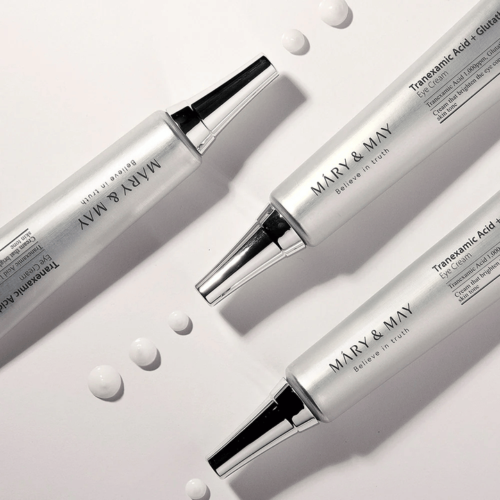 Image de produit stylisée de Mary&May Tranexamic Acid + Glutathione Eye Cream montrant la consistance de la crème et l'accent sur le soin éclaircissant des yeux.