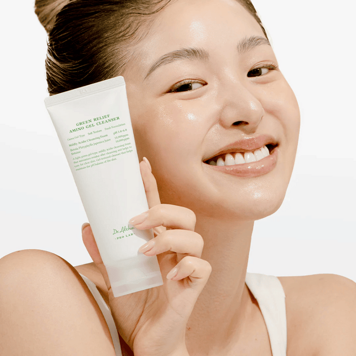 Femme à la peau éclatante tenant Dr. Althea Green Relief Amino Gel Cleanser – nettoyage vegan pour les peaux sensibles et irritées.