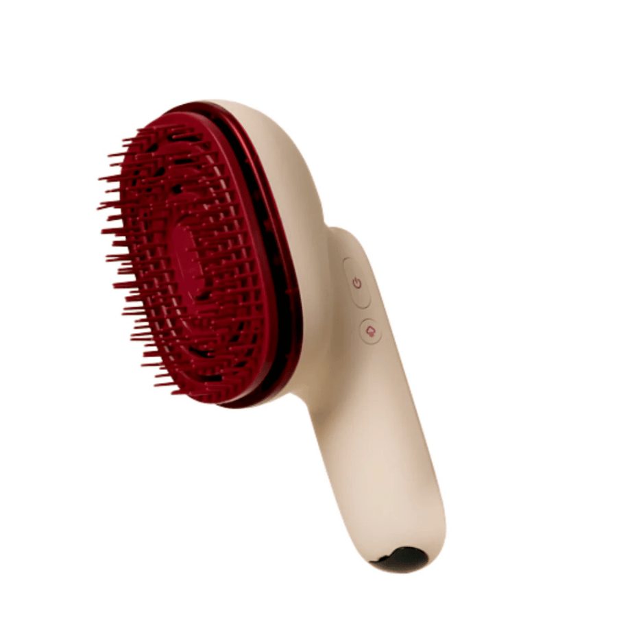 Gros plan sur MOEV Hair Steamer Pro avec des poils rouges et une poignée ergonomique. Brosse de soin des cheveux professionnelle avec vapeur et technologie LED.