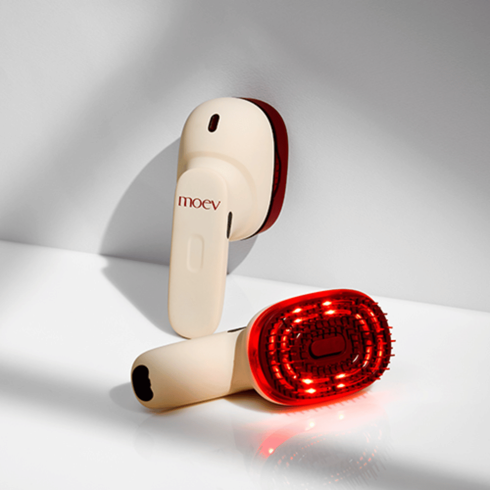 Deux MOEV Hair Steamer Pro sur fond blanc. L'un montre des lumières LED rouges activées qui stimulent le cuir chevelu et améliorent la croissance des cheveux.