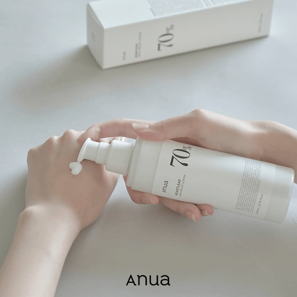 Une personne tient une bouteille Anua Heartleaf 70% Daily Lotion 200ml.