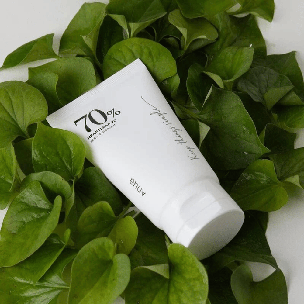 Un tube de Heartleaf 70% Soothing Cream repose sur un lit de feuilles vertes.