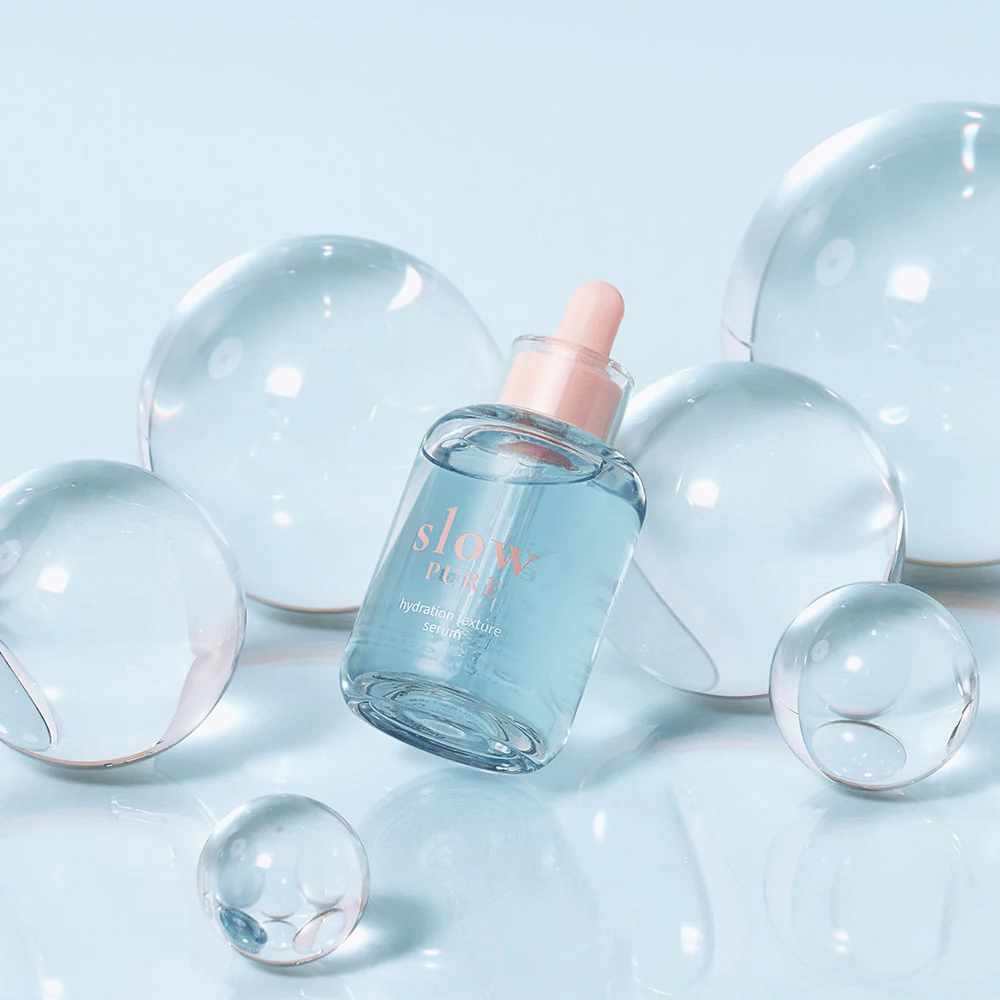 Slow Pure Hydration Texture Serum placée parmi des bulles transparentes, symbole d'hydratation intense.