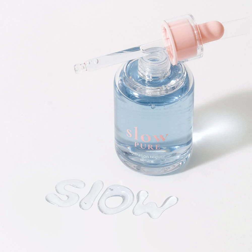 Slow Pure Hydration Texture Serum avec pipette ouverte, texte écrit dans le sérum à la surface : "Slow".