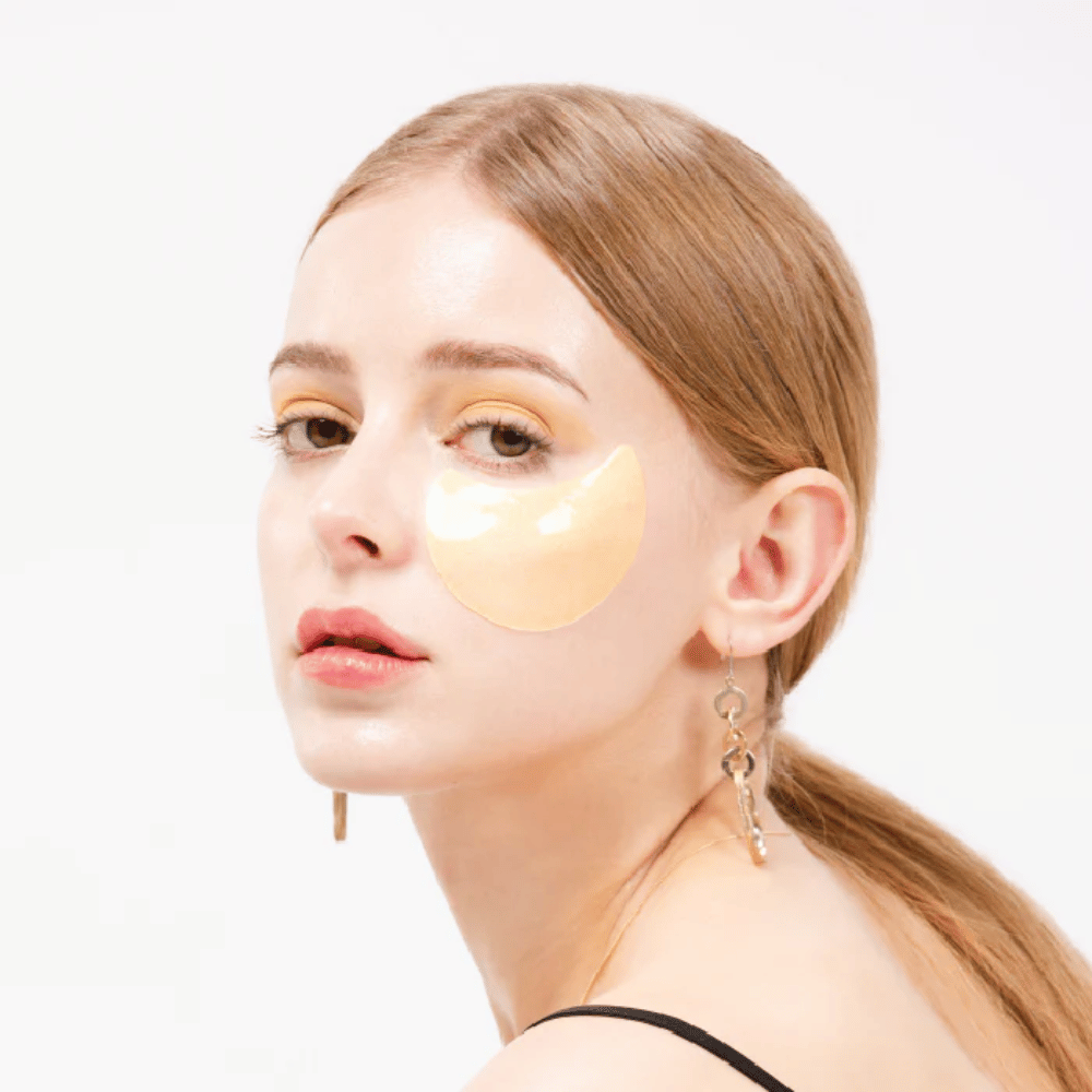 Modèle portant un patch pour les yeux en hydrogel scintillant doré sous l'œil pour un effet lumineux.