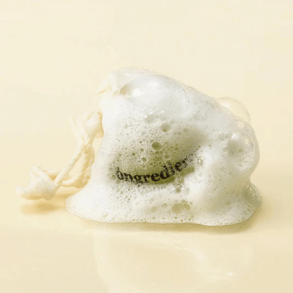 Óngredients Jeju Green Tea Cleansing Ball dans un sac en filet couvert de mousse douce – savon facial coréen naturel.