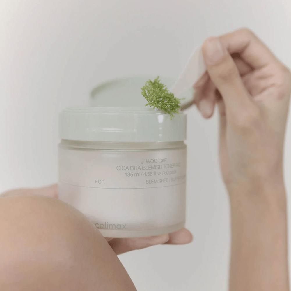 Celimax Ji Woo Gae Cica BHA Blemish Toner Pad avec extrait de centella montré en utilisation – exfoliation douce pour une peau claire.