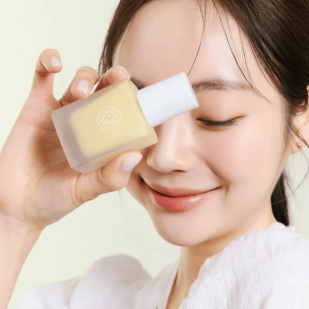 Une femme tient un flacon KAINE Vita Drop Serum de 30ml.