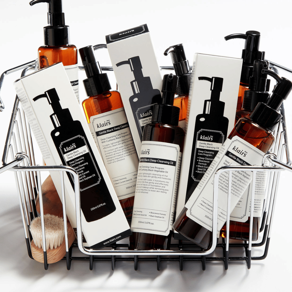 Un mini-chariot rempli de produits de soins de la peau de Klairs, y compris Gentle Black Deep Cleansing Oil dans des flacons transparents avec des pompes noires et des emballages assortis.