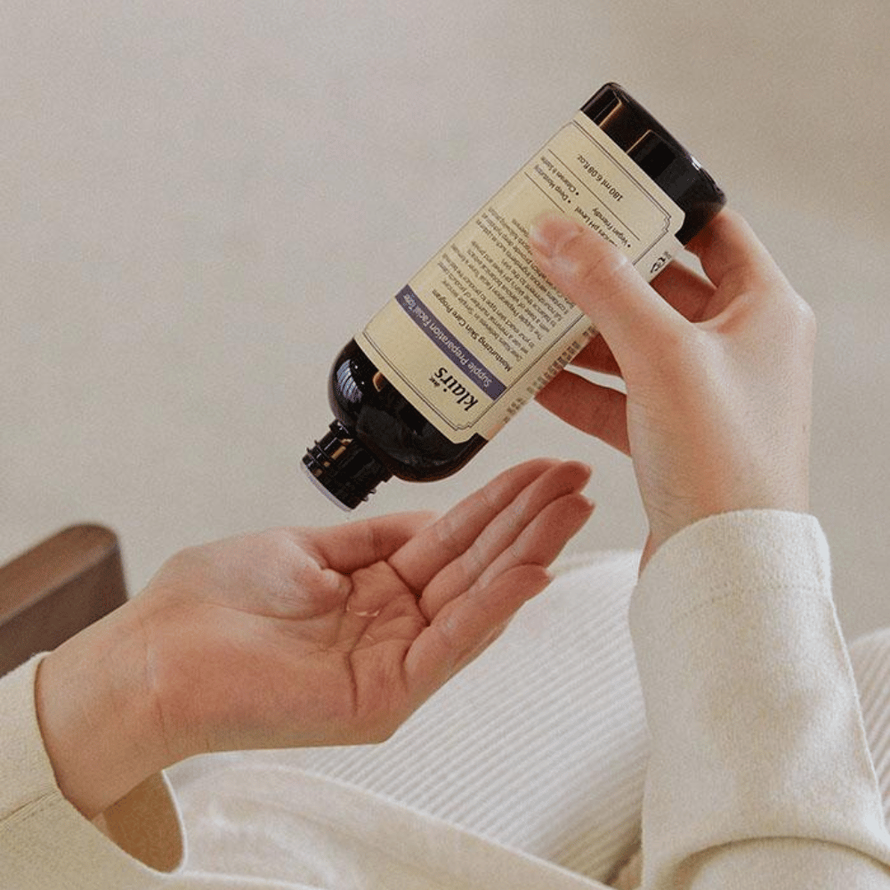 Une personne tient une bouteille de Klairs Supple Preparation Facial Toner à l'envers au-dessus de sa main, prête à doser le produit.