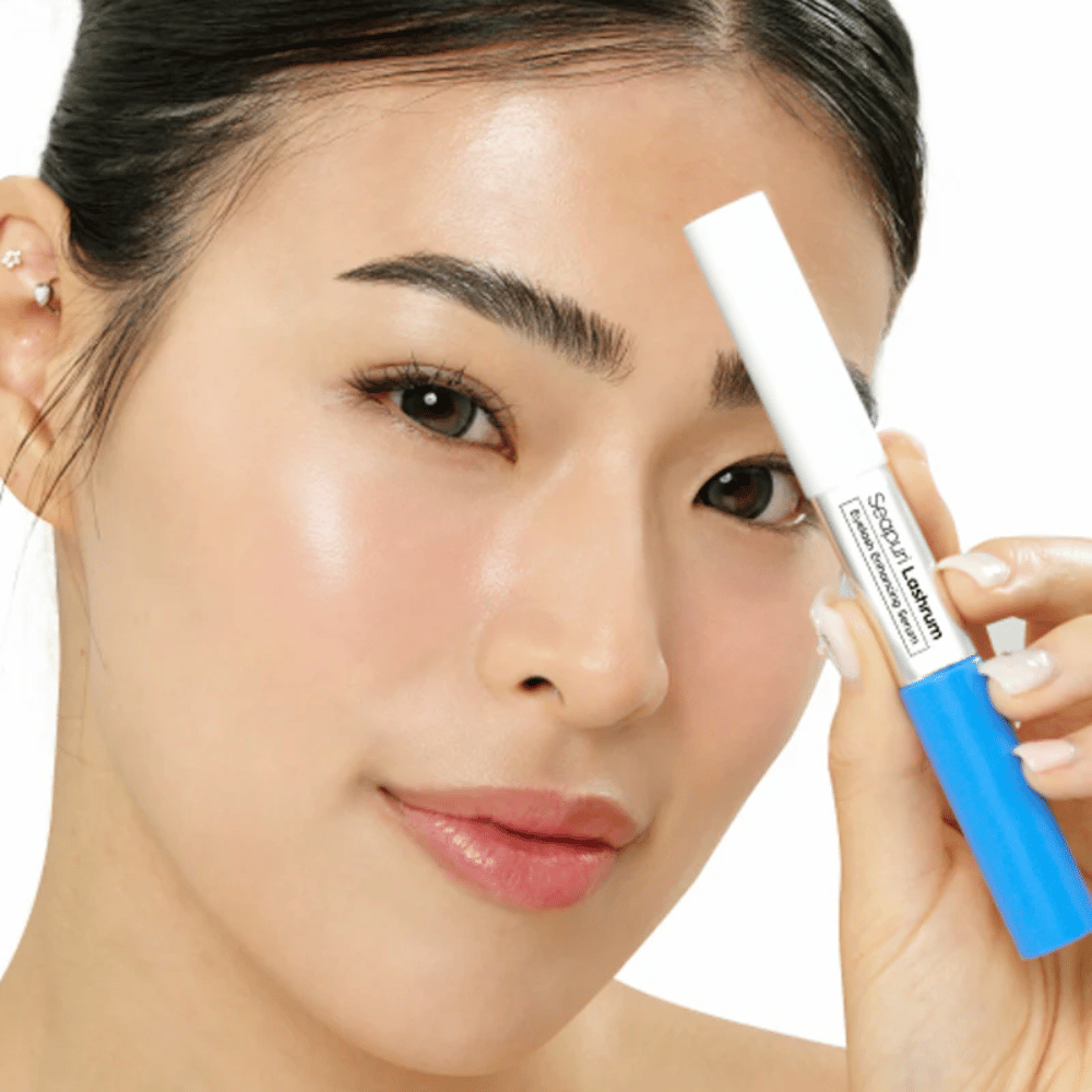 Femme tenant Seapuri Lashrum Eyelash Enhancing Serum. Un sérum pour cils nourrissant qui renforce et définit les cils.