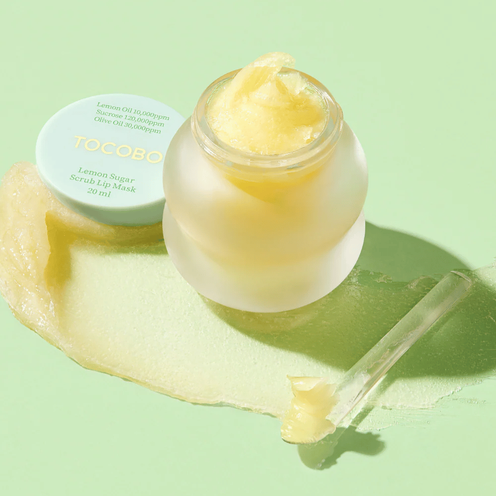 Pot ouvert avec Tocobo Lemon Sugar Scrub Lip Mask sur un fond vert, avec le contenu clairement visible.
