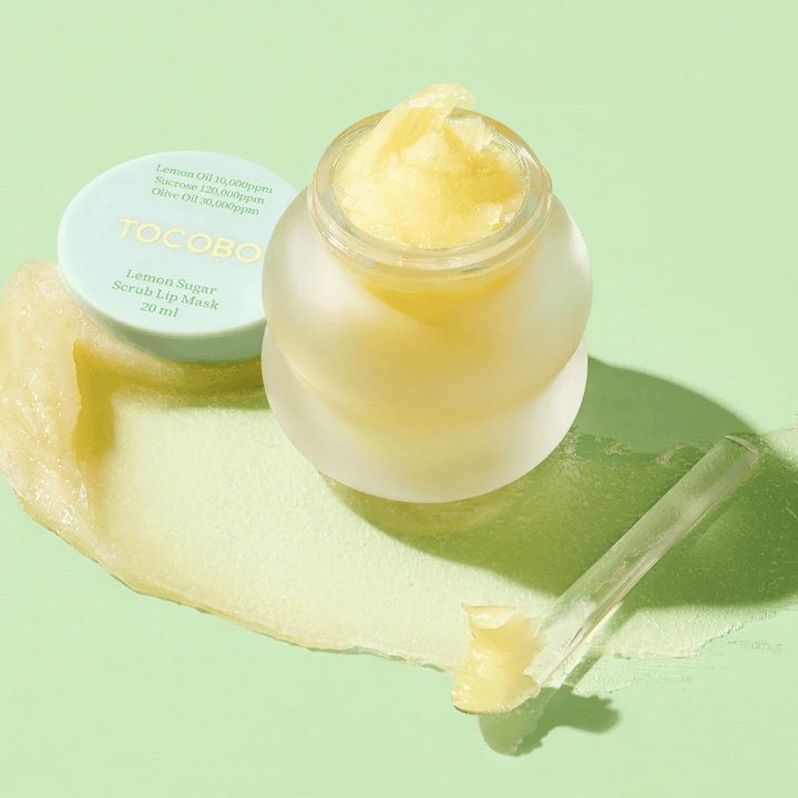 Pot ouvert avec Tocobo Lemon Sugar Scrub Lip Mask sur un fond vert, avec le contenu clairement visible.
