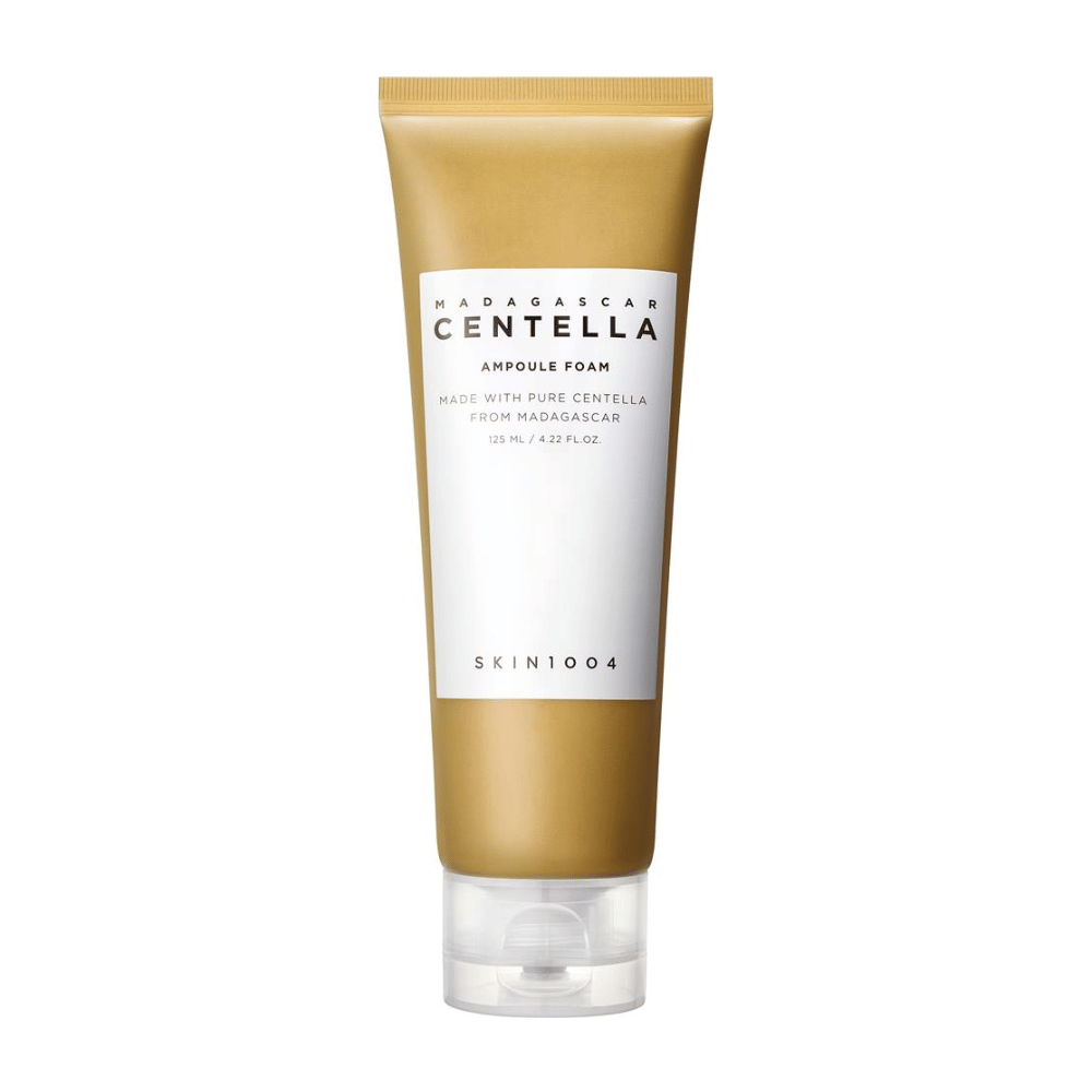 L'image montre un tube de "Madagascar Centella Ampoule Foam" de la marque SKIN1004. C'est un produit nettoyant pour le visage qui contient 125 ml / 4.22 fl.oz. La formule est basée sur de l'extrait pur de Centella provenant de plantes de Madagascar. Le produit est conçu pour nettoyer et prendre soin de la peau en douceur.