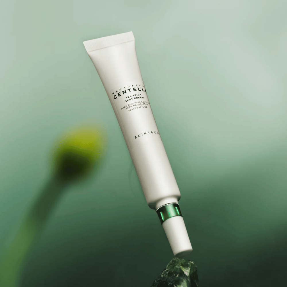 SKIN1004 Madagascar Centella Tea-Trica Spot Cream flottant sur fond vert – traitement localisé efficace treatment pour les peaux sujettes à l'acné avec centella de Madagascar.