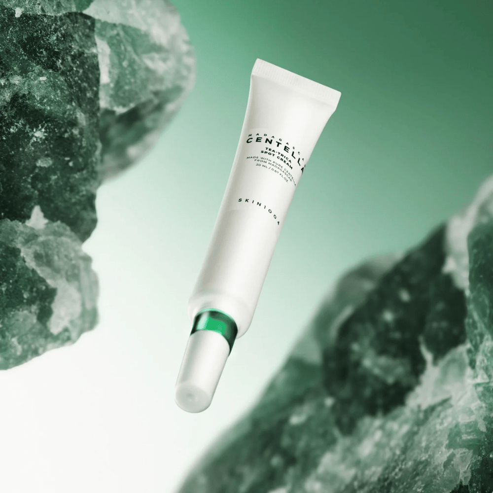 SKIN1004 Madagascar Centella Tea-Trica Spot Cream 20 ml contre l'acné et les boutons, image du produit avec fond vert et structure cristalline – traitement apaisant localisé avec centella asiatica et tea tree.