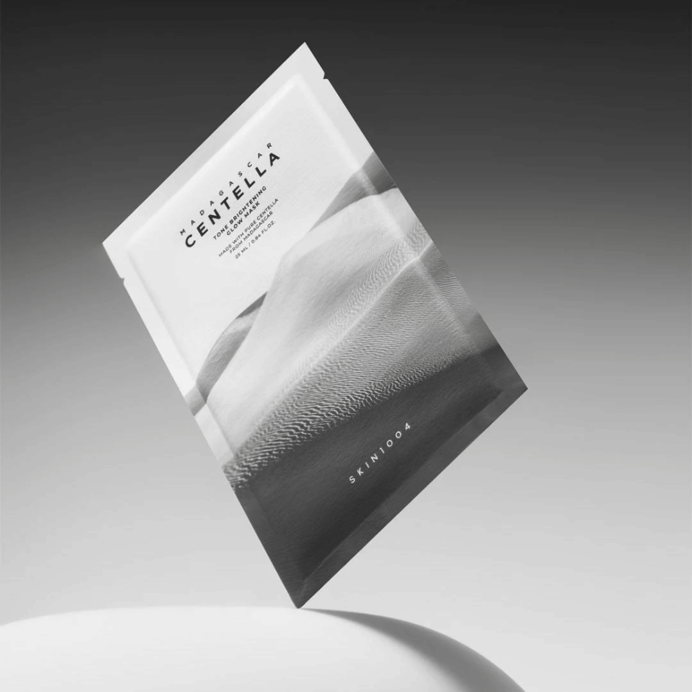 Emballage Sheet mask de SKIN1004 flottant sur fond gris avec un design minimaliste.