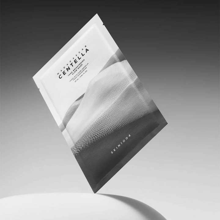 Emballage Sheet mask de SKIN1004 flottant sur fond gris avec un design minimaliste.