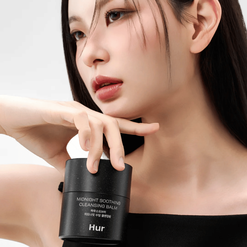 Modèle tenant Comment Midnight Soothing Cleansing Balm. Baume nettoyant coréen qui élimine efficacement le maquillage et nettoie la peau sans irritation.