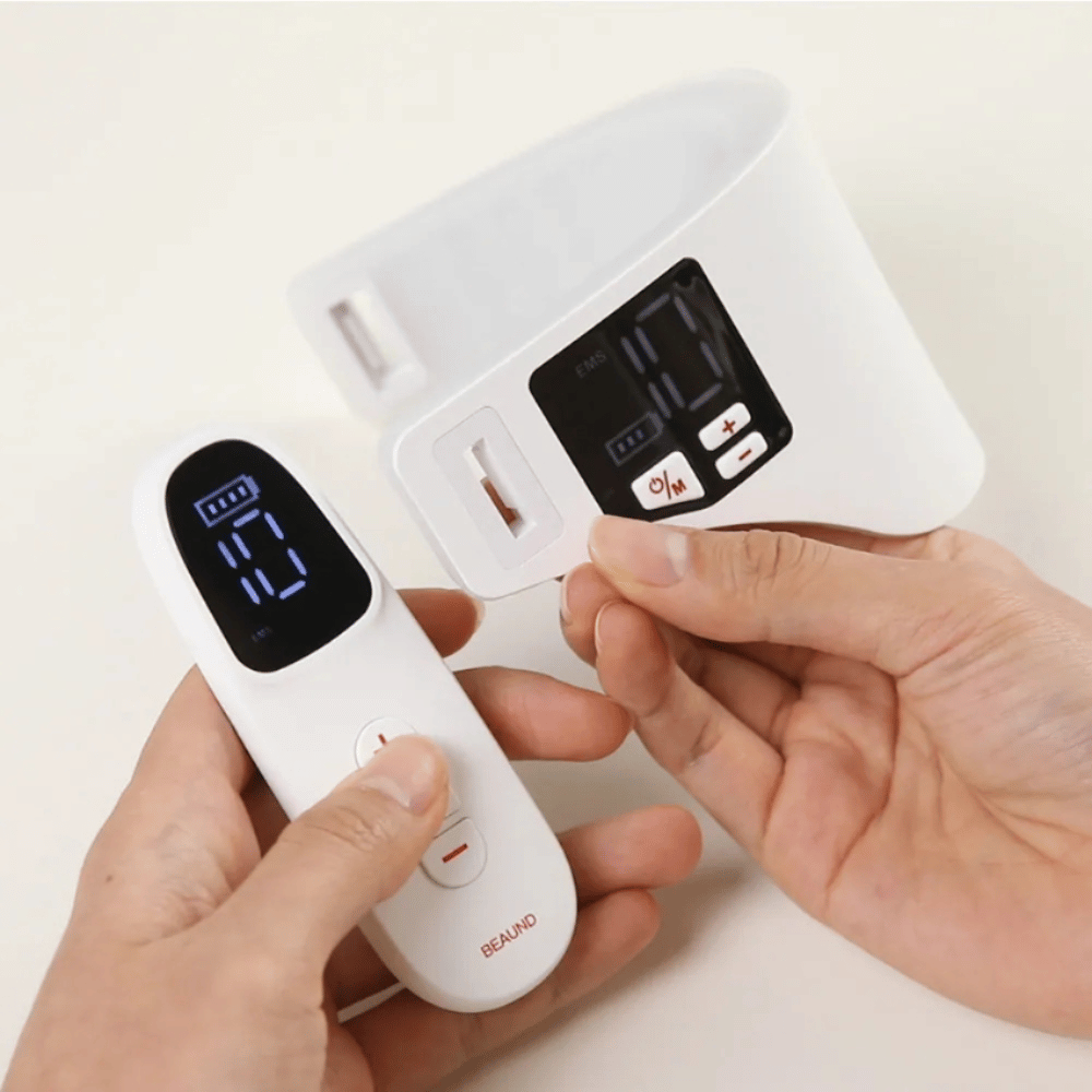 Beaund Neckcera est présenté avec la télécommande incluse. L’image démontre le contrôle sans fil ainsi que l’écran numérique où l’intensité et les fonctions peuvent être ajustées.