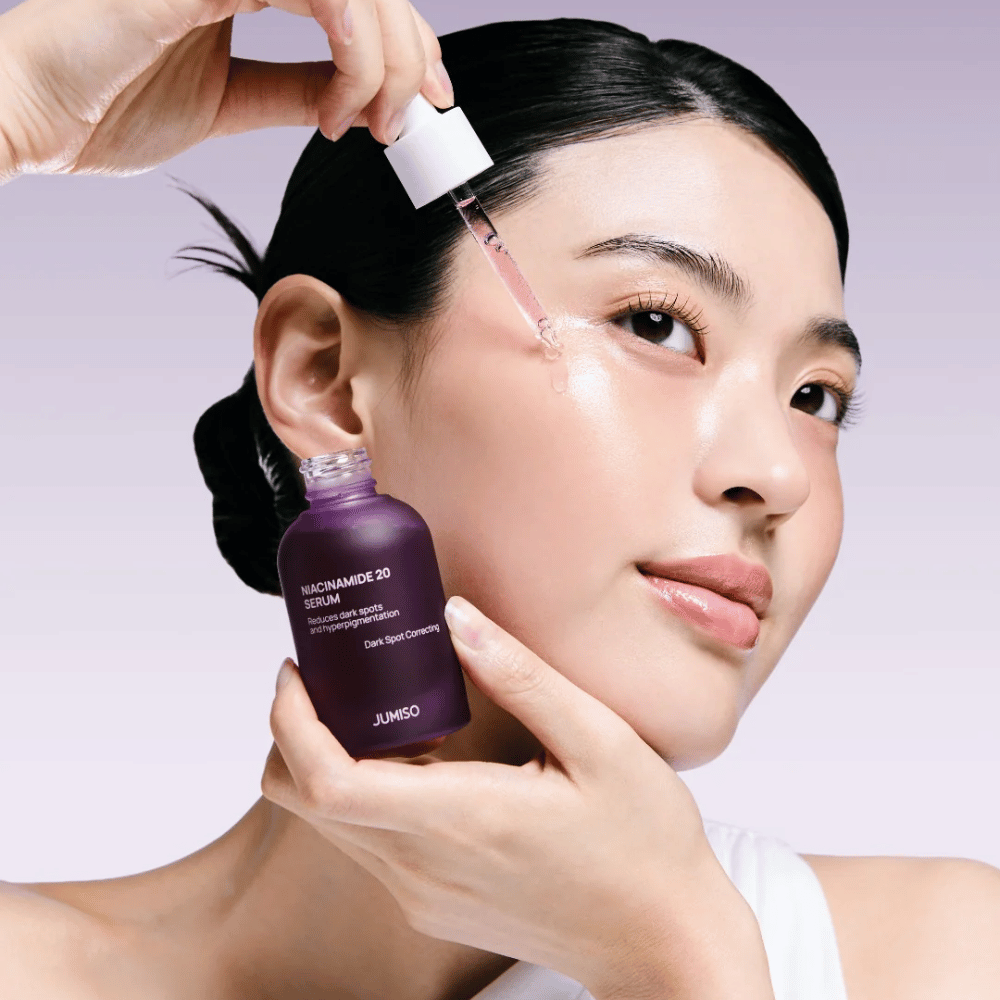 Une femme applique Jumiso Niacinamide 20 Serum – sérum coréen éclatant qui unifie le teint et réduit les taches pigmentaires.