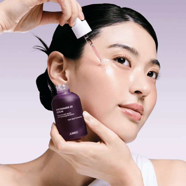 Une femme applique Jumiso Niacinamide 20 Serum – sérum coréen éclatant qui unifie le teint et réduit les taches pigmentaires.