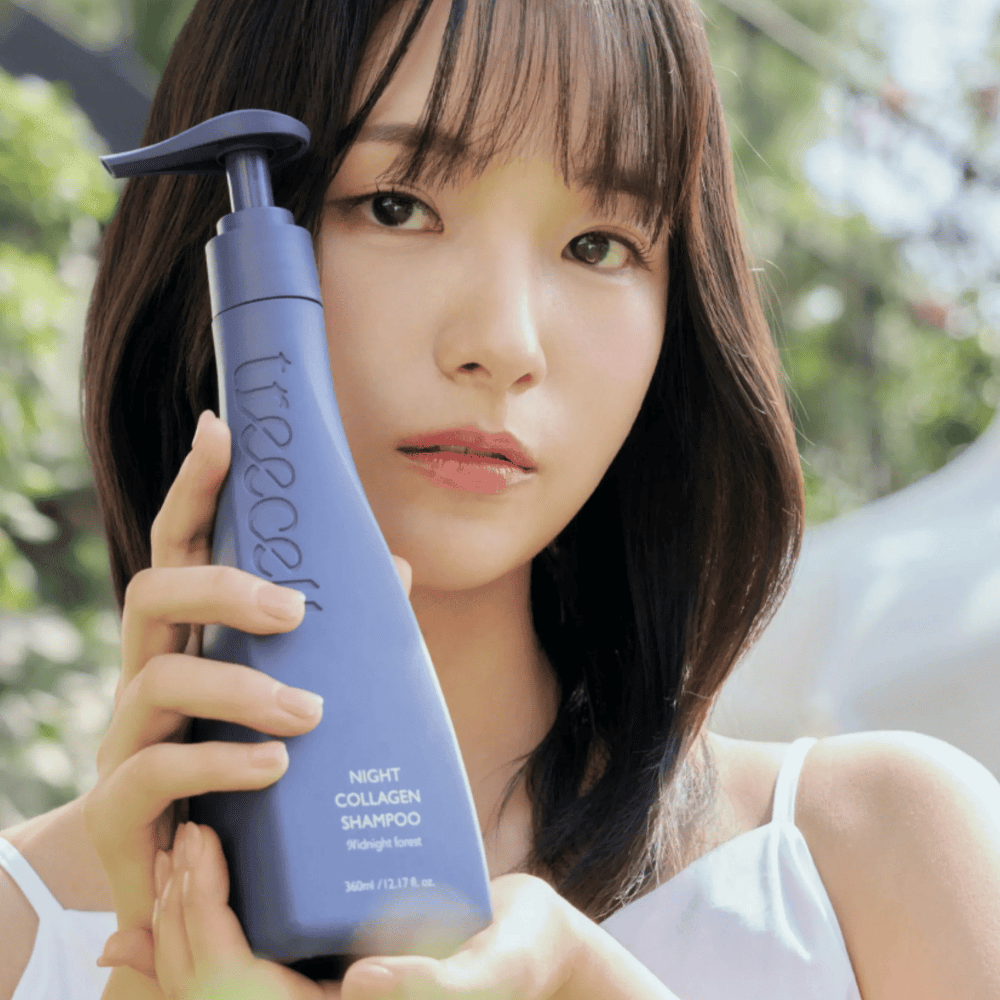 Une femme tient Treecell Night Collagen Shampoo Midnight Forest dans un environnement naturel. L’image transmet des cheveux sains, de la brillance et une sensation premium, avec un focus sur le soin des cheveux et du cuir chevelu.