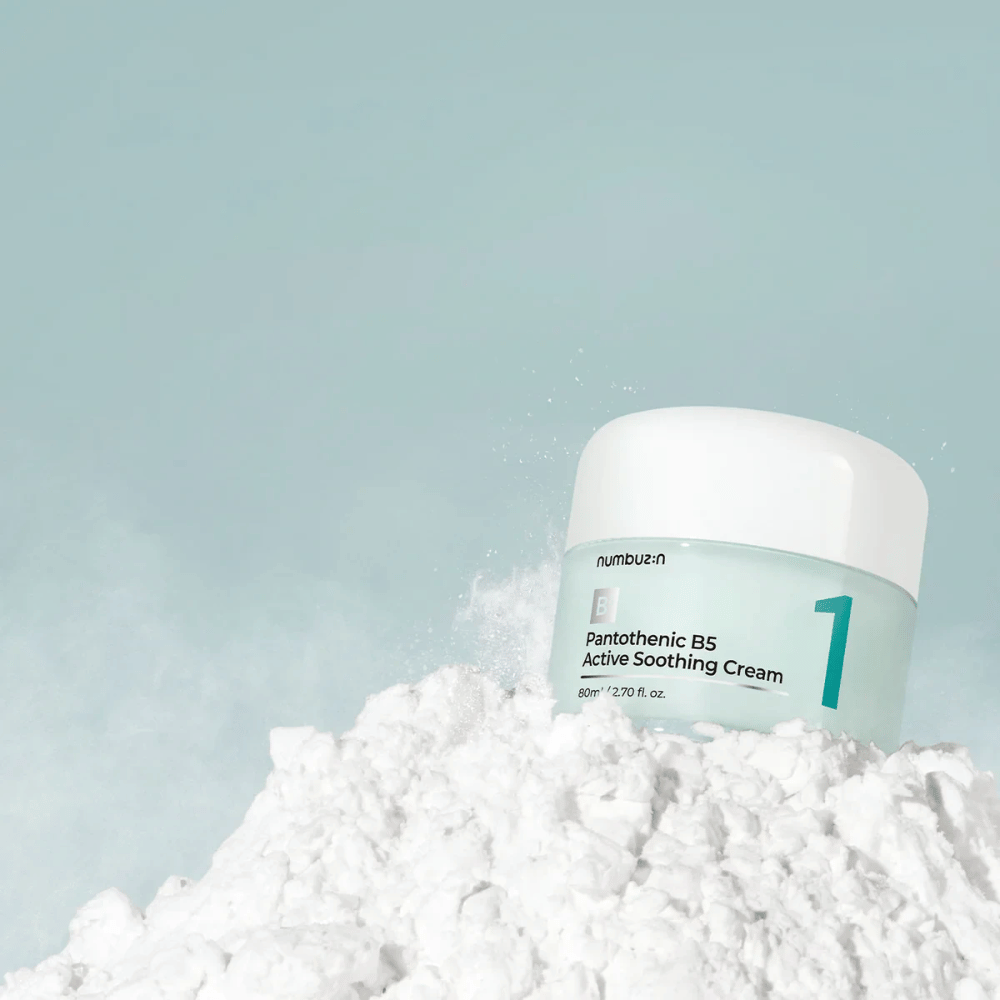 Numbuzin No.1 Pantothenic B5 Active Soothing Cream 80 ml dans un pot vert clair avec un couvercle blanc, placé sur un tas de poudre blanche sur un fond clair.