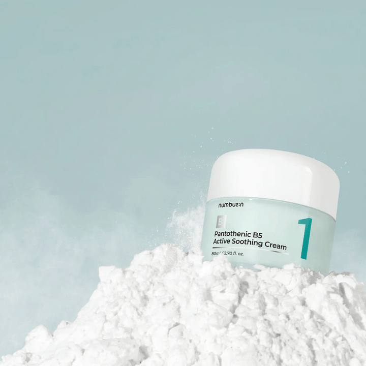 Numbuzin No.1 Pantothenic B5 Active Soothing Cream 80 ml dans un pot vert clair avec un couvercle blanc, placé sur un tas de poudre blanche sur un fond clair.