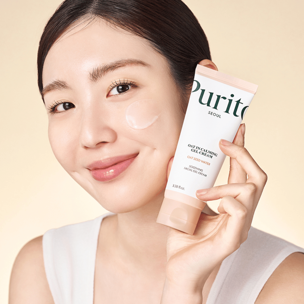 Une femme applique Purito Oat-In Calming Gel Cream sur le visage. Crème-gel douce et hydratante pour les peaux sensibles et irritées.