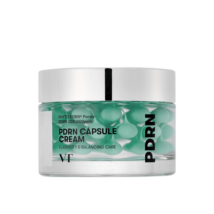 VT PDRN Capsule Cream dans un pot transparent avec un couvercle argenté. Le contenu se compose de capsules vertes dans un gel clair, et l'étiquette indique que la crème est destinée à l'élasticité et aux soins équilibrants de la peau.