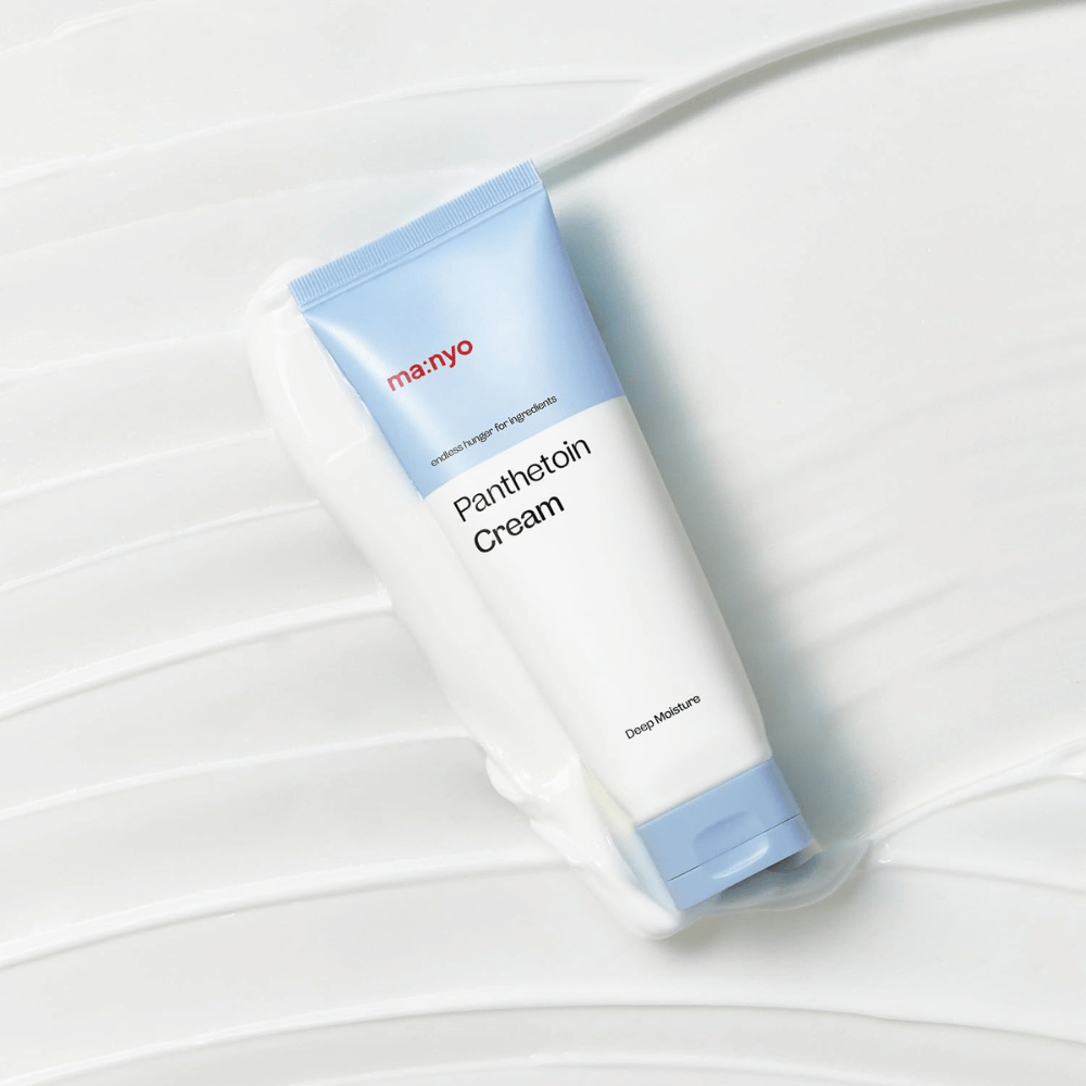 2. Ma:nyo Panthetoin Cream – crème visage hydratant dans un tube blanc et bleu clair entouré d'une texture crémeuse sur fond blanc