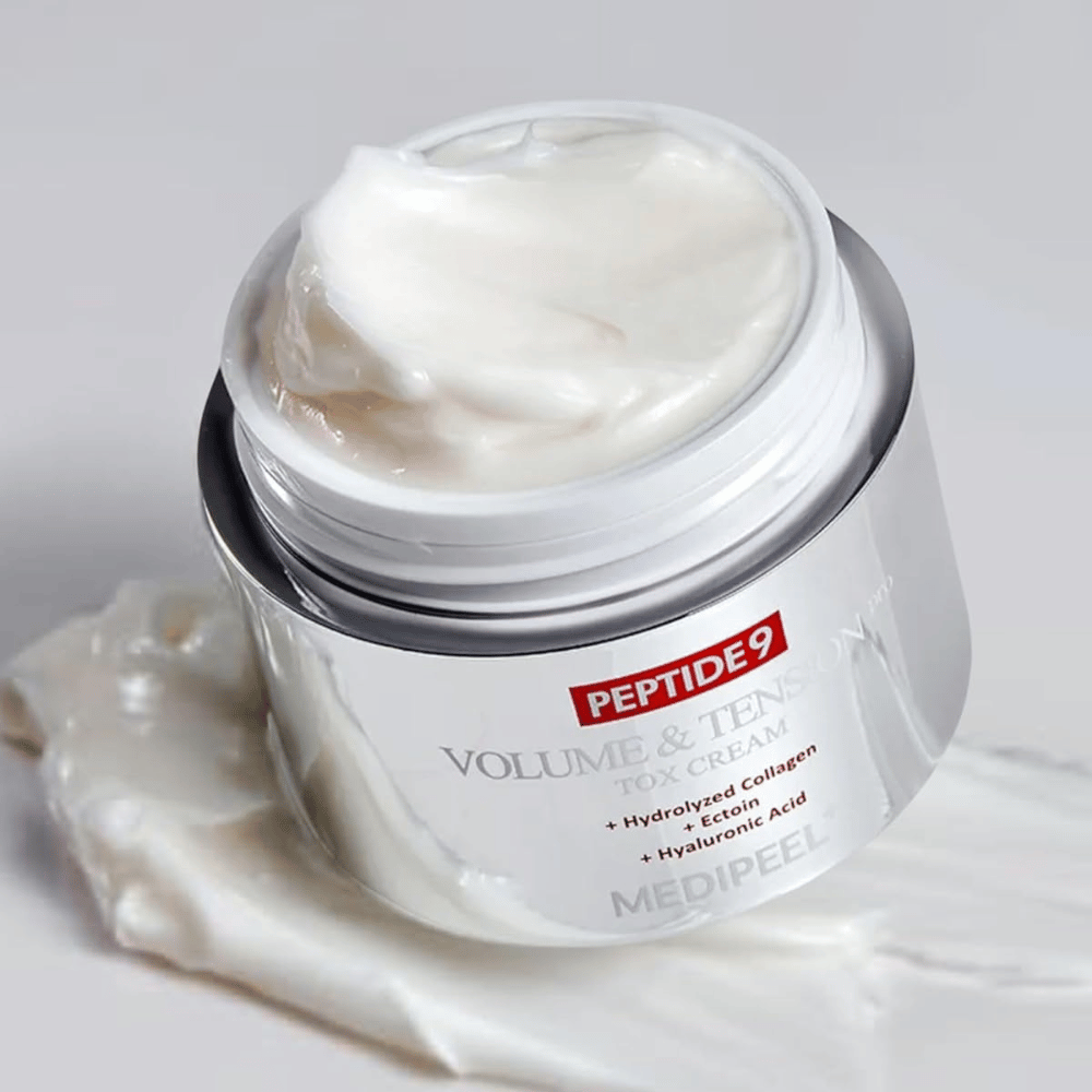 Gros plan sur MEDI-PEEL Peptide 9 Volume & Tension Tox Cream. La crème riche contient du collagène hydrolysé, de l'ectoïne et de l'acide hyaluronique pour une peau plus ferme et hydratée.