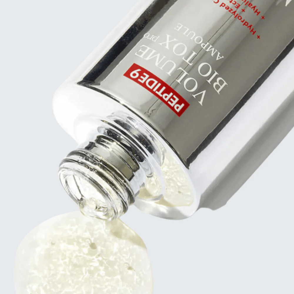 Gros plan sur MEDI-PEEL Peptide 9 Volume Bio Tox Pro Ampoule en train d'être versé. La formule claire avec collagène, ectoïne et acide hyaluronique hydrate en profondeur.