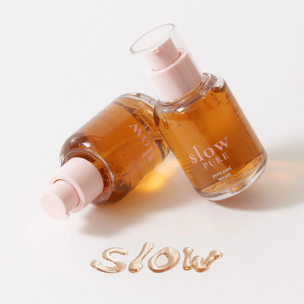 Deux bouteilles de Slow Pure Pore Peel Serum avec pompe, texte écrit dans le sérum à la surface : "Slow".