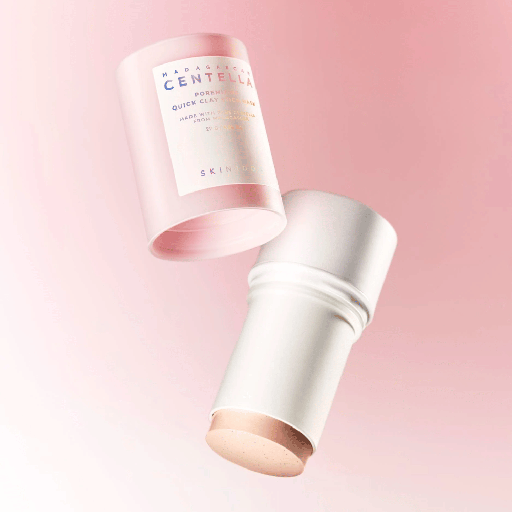 SKIN1004 Madagascar Centella Poremizing Quick Clay Stick Mask dans un design élégant rose et blanc. Format stick pratique pour une application facile et un nettoyage en profondeur.