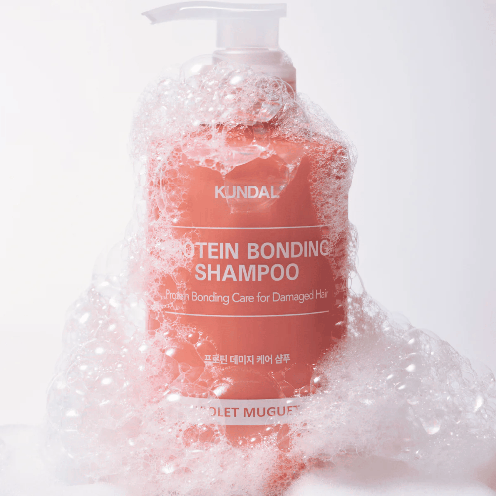 KUNDAL Protein Bonding Shampoo Violet Muguet recouvert de mousse abondante, shampoing réparateur pour cheveux abîmés.