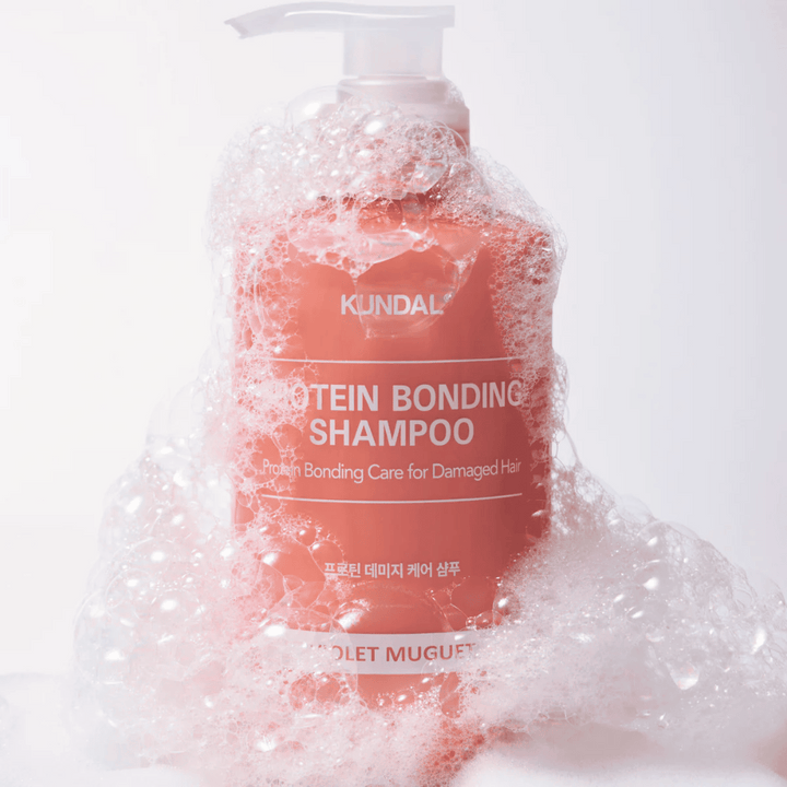 KUNDAL Protein Bonding Shampoo Violet Muguet recouvert de mousse abondante, shampoing réparateur pour cheveux abîmés.