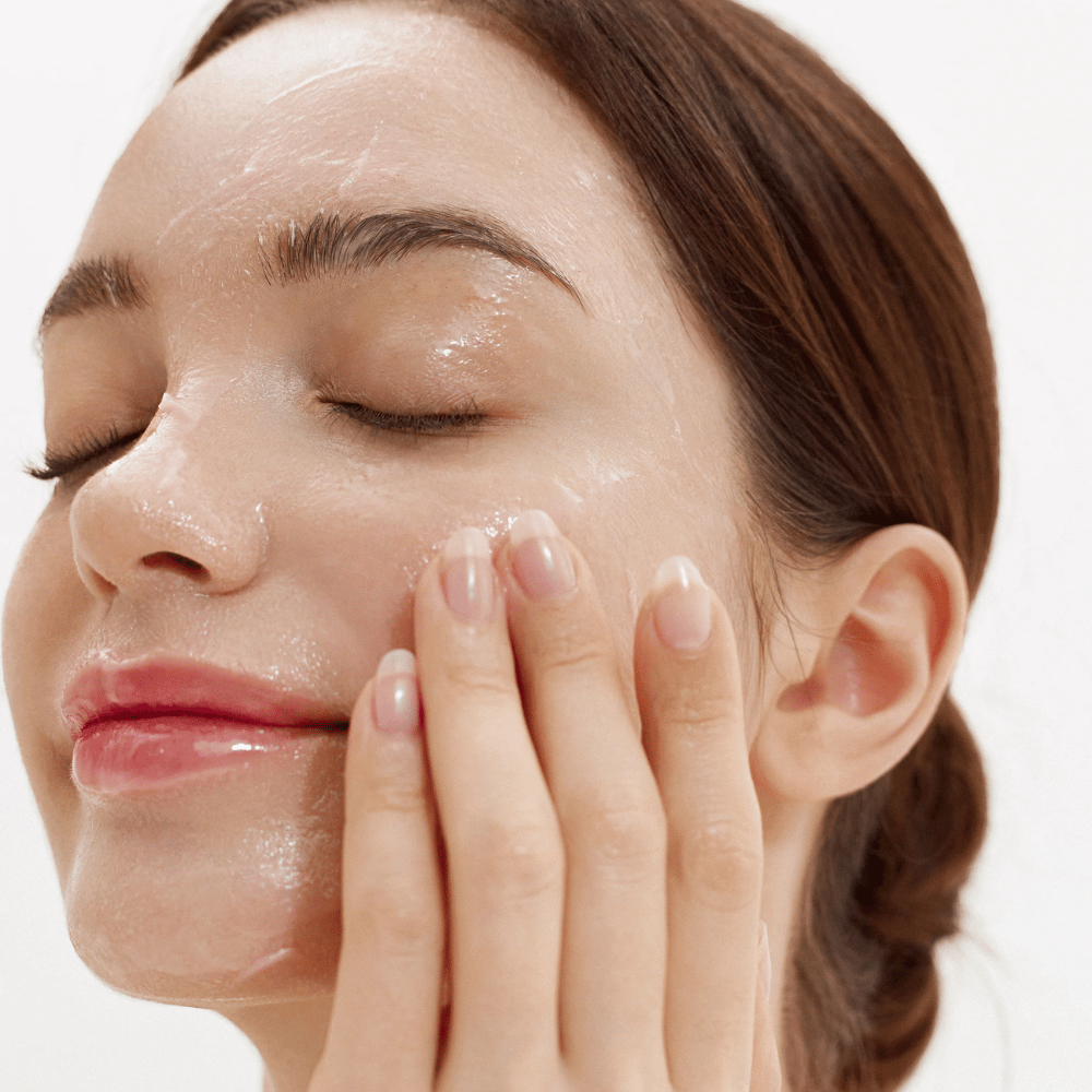 Comment Purifying Cleansing Balm appliqué sur le visage. Baume crémeux qui fond au contact de la peau et élimine en douceur la saleté, la protection solaire et le maquillage.