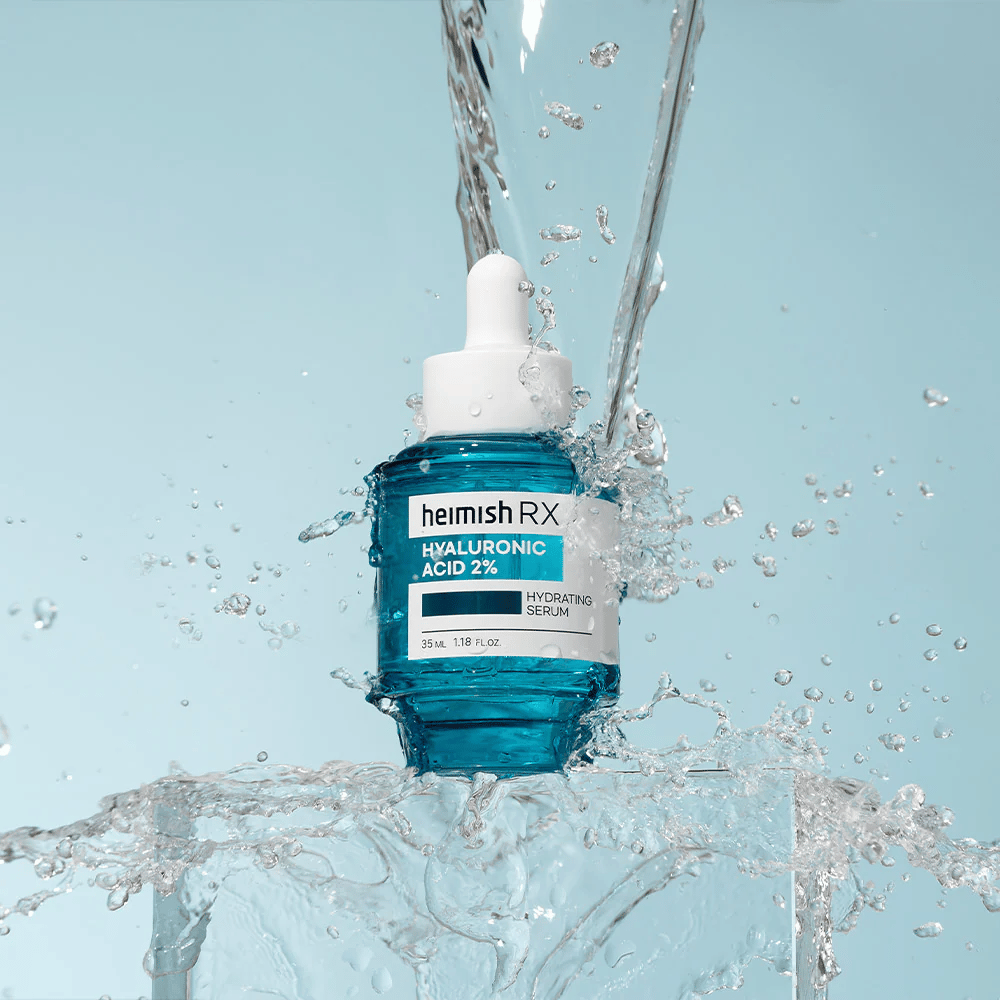 Heimish RX Hyaluronic Acid 2% Hydrating Serum placé sur une surface semblable à de la glace avec de l'eau éclaboussant autour, symbolisant une hydratation intense et une fraîcheur.
