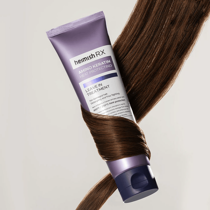 Heimish RX Amino Keratin Leave-In Treatment – traitement capillaire nourrissant et protecteur thermique entouré de cheveux brillants, symbolise l'effet fortifiant et hydratant pour cheveux abîmés.