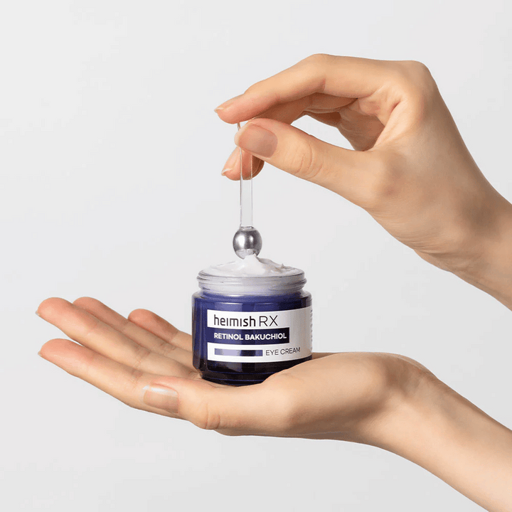 Heimish RX Retinol Bakuchiol Eye Cream dans un pot bleu élégant, soulevé avec un applicateur métallique. Une crème pour les yeux avec rétinol et bakuchiol pour réduire les rides fines et donner une peau plus ferme.