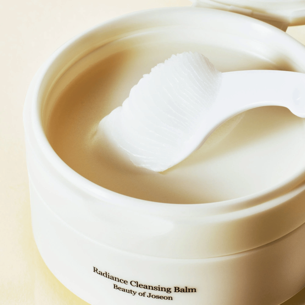 Gros plan sur Beauty of Joseon Radiance Cleansing Balm dans un pot avec la spatule – baume soyeux qui nettoie et hydrate.