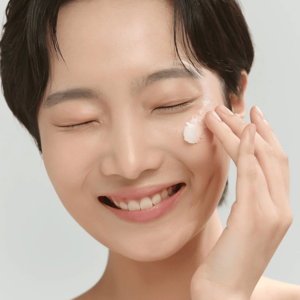 Modèle avec une peau éclatante appliquant Beauty of Joseon Radiance Cleansing Balm – baume nettoyant coréen qui dissout le maquillage et les impuretés.
