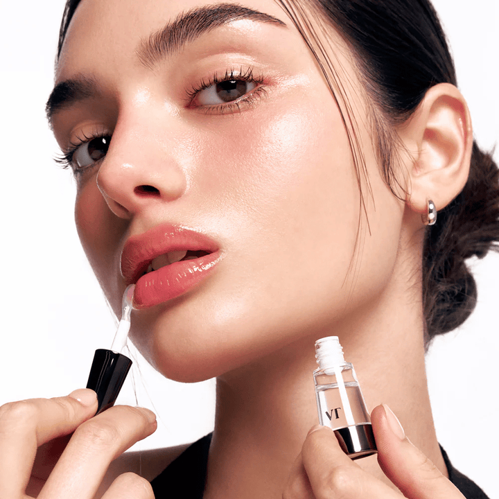 Un modèle applique VT Cosmetics Reedle Shot Lip Plumper Beginner sur les lèvres pour un effet repulpant naturel, de la brillance et de l'hydratation avec un léger effet picotant.