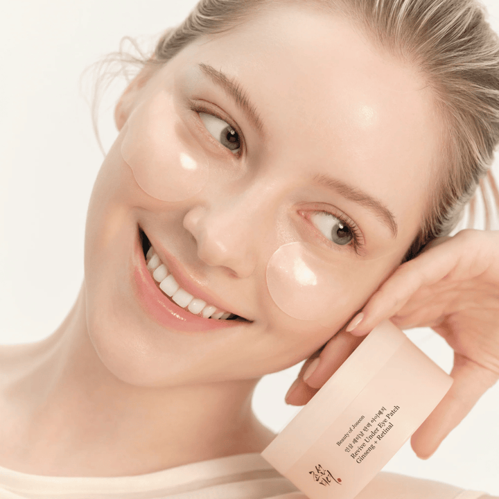 Modèle avec Beauty of Joseon patchs pour les yeux et produit en main, patchs pour les yeux avec ginseng et retinal pour une zone des yeux plus éveillée et plus lisse.