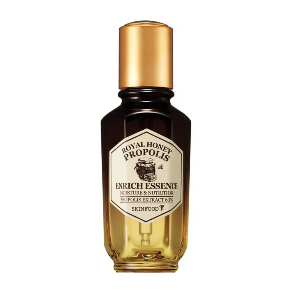 Image d'une bouteille en verre avec un liquide sombre et un bouchon doré. Sur l'étiquette de la bouteille est écrit "Royal Honey Propolis Enrich Essence" suivi de "Moisture & Nutrition" et "Propolis Extract 63%". La marque "Skinfood" apparaît également en bas de l'étiquette.