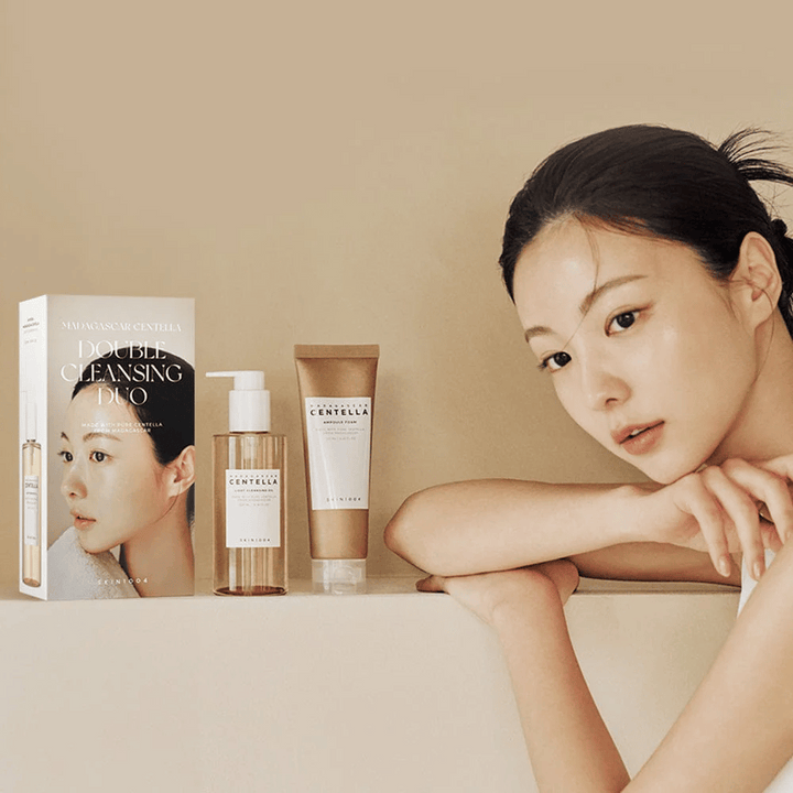 SKIN1004 Madagascar Centella Double Cleansing Duo Set avec boîte, nettoyage à base d'huile, nettoyage à la mousse et modèle avec peau hydratée sur fond beige.